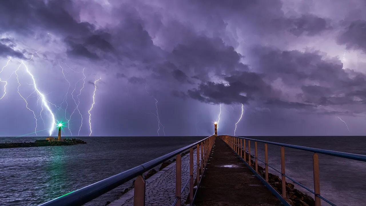 Bliksem tijdens een nachtelijk onweer boven de haven en vuurtoren van Port-la-Nouvelle, in het departement Aude in Zuid-Frankrijk.